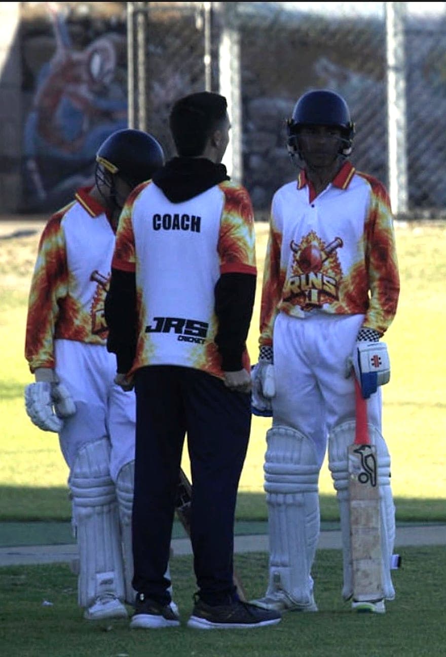 Koby talking with two junior batters mid-match